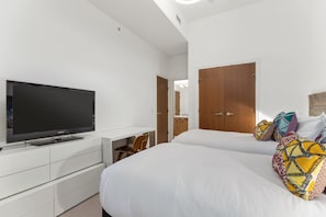 A hotel room with a bed, a television, a desk, and a wardrobe.
