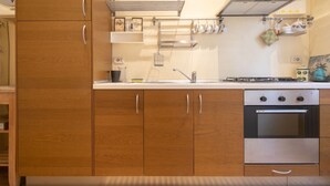 Una cocina con armarios de madera, horno de acero inoxidable y escurreplatos.