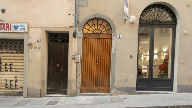 Un edificio con puerta de madera, un letrero de tienda y un escaparate.