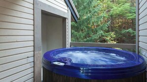 A hot tub in a wooden structure with a view of a forest. - Whistler retreat w/ private hot tub & ski access (Whistler)