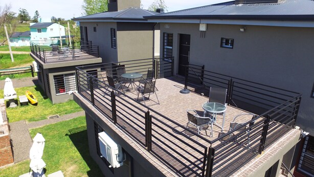 A rooftop patio with outdoor furniture, a small table, and a chair. - Mi Gran Amor Termas (San José)