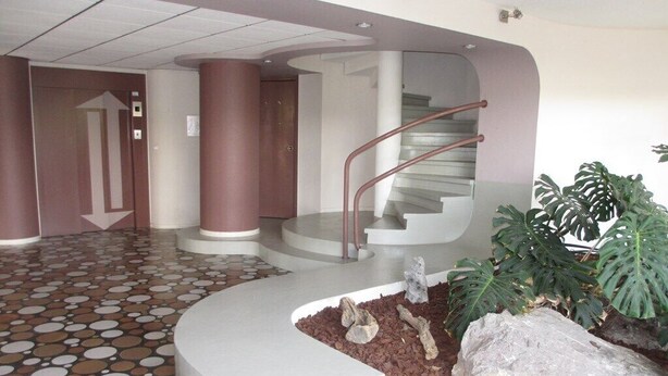 A lobby with a circular staircase, a tiled floor, and a planter with rocks and plants. - CAP SUD residence- Flat for 3 persons close to marina (CAPBRETON)