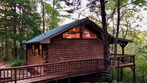 A wooden cabin with a balcony, surrounded by trees. - Tranquil Cabin- Perched on Mountain Top boasting jacuzzi for two and expansive deck with views! Trail & Cave on Property! (Eureka Springs)