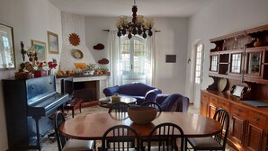 Un coin repas avec une table et des chaises en bois, un téléviseur et une cheminée.