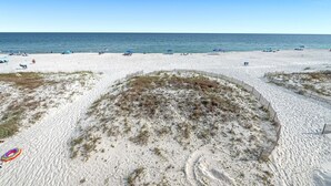 A sandy beach with a wooden fence and a clear blue sky. - 🥳 Early Bird Sale! 🥰 Beach Axis, East. 5BR Beachfront Beauty. Pool. Perfect location. (Gulf Shores)