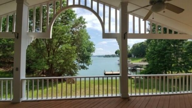 A covered outdoor area with a view of a lake and trees.