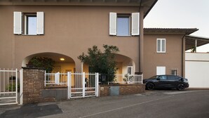 A two-story building with a brown facade, white shutters, and a car parked in front. - House of Arts apartments ♠ (Montelupo Fiorentino)