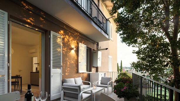 An outdoor balcony with a dining set, a potted plant, and a view of the cityscape. - House of Arts apartments ♠ (Montelupo Fiorentino)