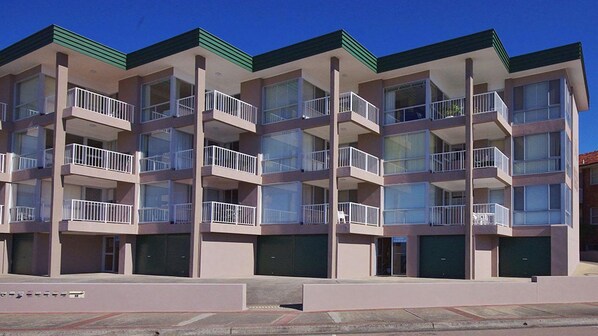 A multi-story building with balconies, large windows, and a flat roof. - Oceanfront Escape at Dolphin Court (The Entrance)