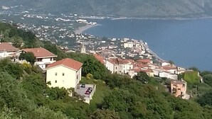 Une ville côtière avec des bâtiments construits sur une colline, d’où l’on a une vue sur la mer et les montagnes.