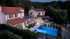 A residential property with a swimming pool, multiple buildings, and a lush green landscape. - Modern Villa Future**** with an outdoor heated pool in a quiet village on Krk (Klimno)