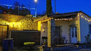 A stone house with a porch, a small table, and chairs. - Romantic cottage on a farm with a view of Cortona (Cortona)