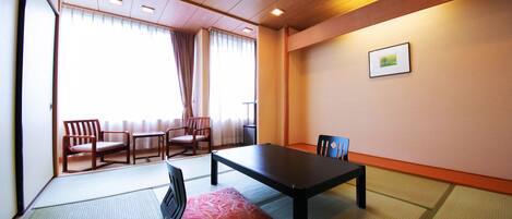 Una habitación japonesa tradicional con suelo de tatami, una mesa baja y sillas de madera.