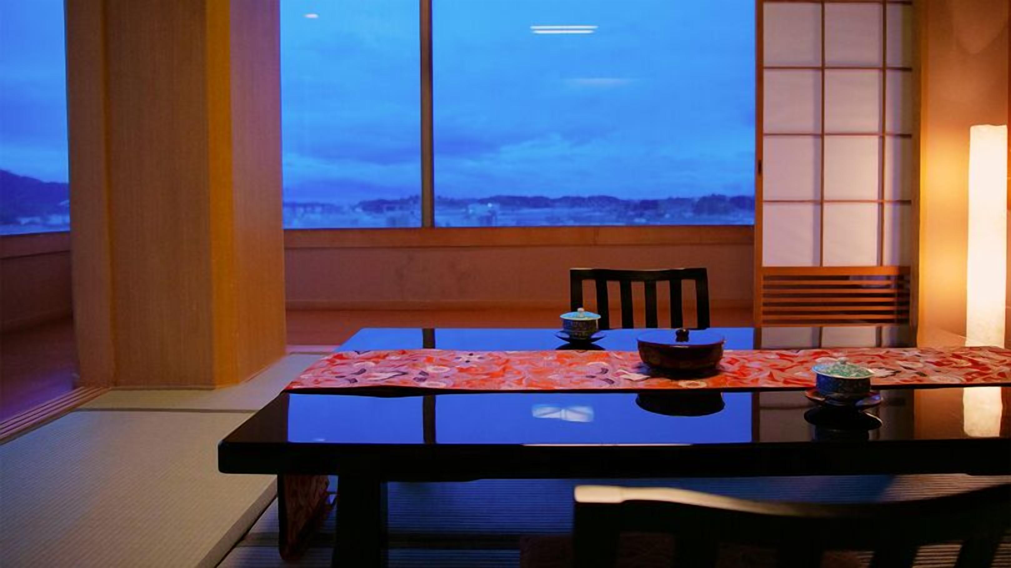 Une table à manger offrant une vue sur le ciel grâce à de grandes fenêtres.