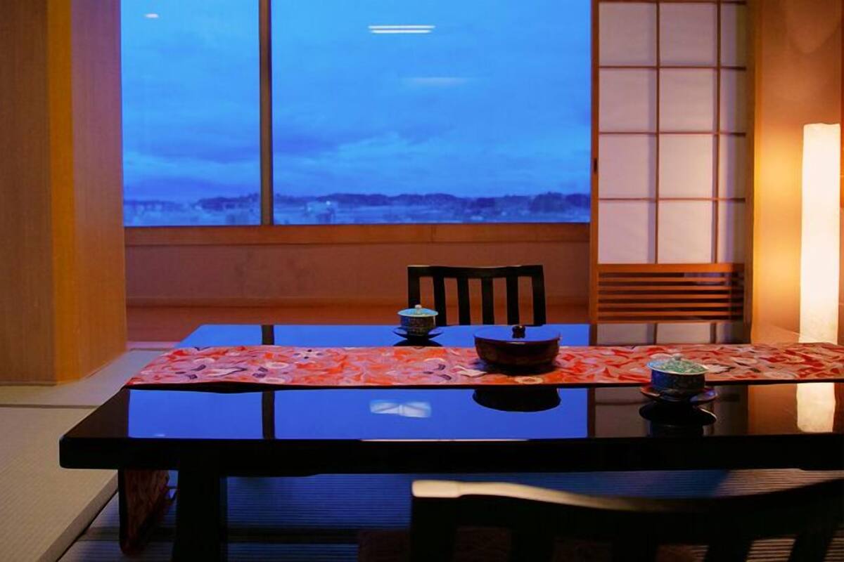 Une table à manger offrant une vue sur le ciel grâce à de grandes fenêtres.