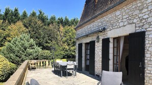 A stone building with a patio area featuring outdoor furniture and a table. - Spacious property in wooded grounds - not overlooked Monpazier - Private swimming pool (Monpazier)