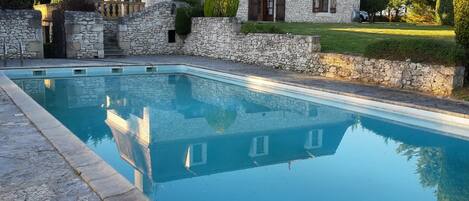 A stone house with a swimming pool.