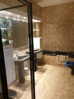 Een bad/douchecombinatie, een haardroger, een bidet, handdoeken