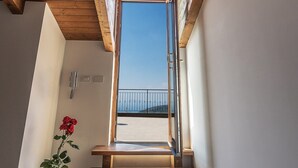 Una scala in legno conduce a un balcone con vista aperta sul cielo.