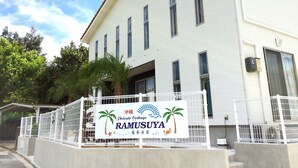 En privat stuga som heter RAMUSUYA, med en skylt, vita ytterväggar och ett rött tegeltak.