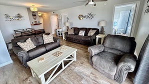 A living room with a sofa, armchair, coffee table, and a ceiling fan. - Cape Coddages I 103 2 Bedroom Condo by RedAwning (Surfside Beach)