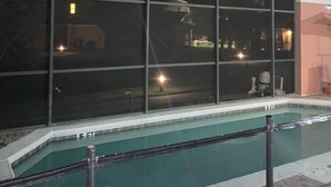 An indoor swimming pool with a covered area and large windows.