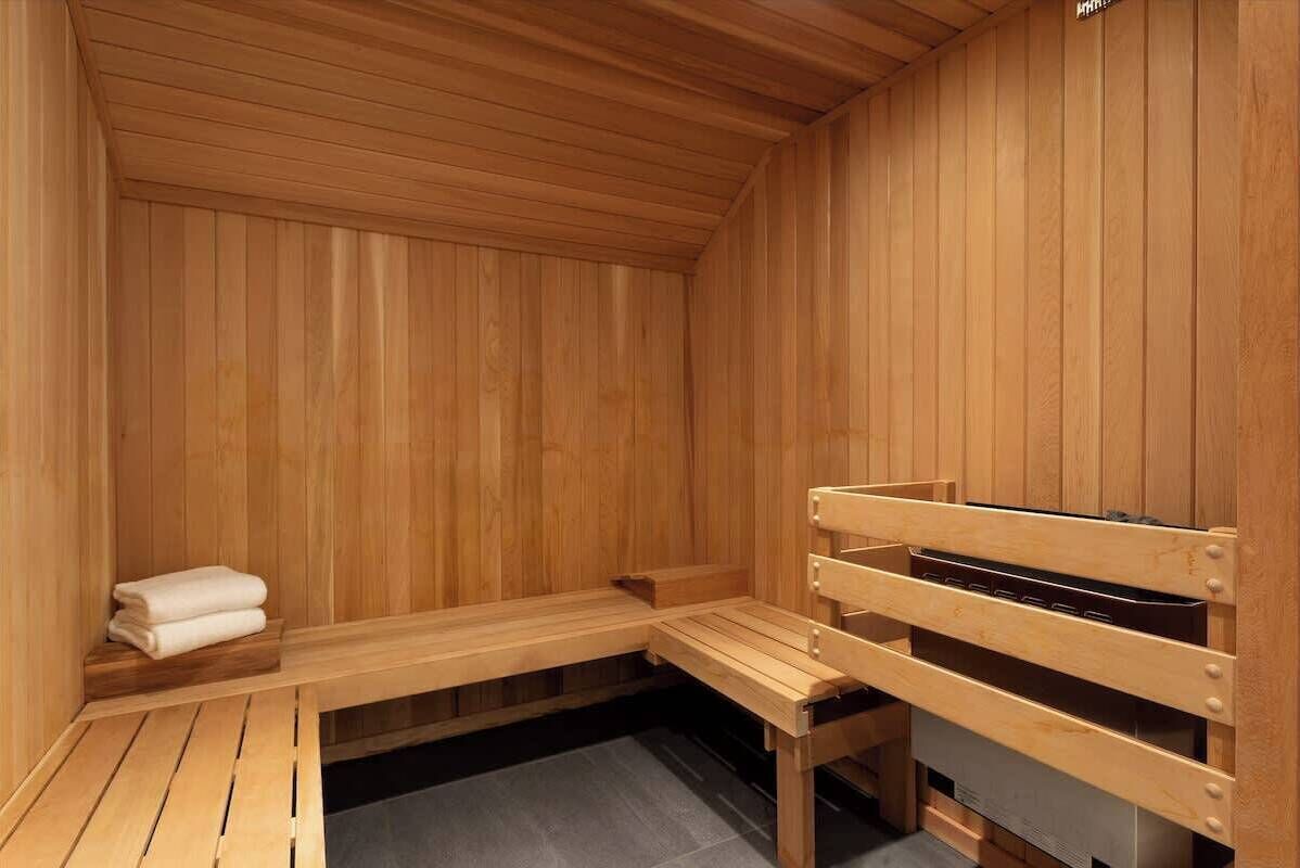 Ein Holzsaunaraum mit Bänken und einem Handtuchhalter.