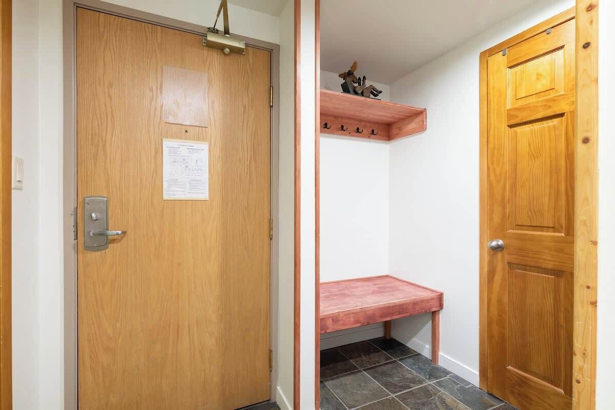 Une porte en bois avec une poignée en métal et une petite étagère au-dessus.