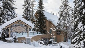 A snow-covered lodge with a wooden exterior and a snow-covered roof.