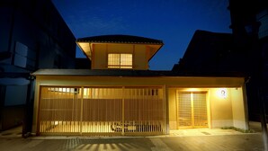 A traditional Japanese house with a wooden gate, a small attached structure, and a tiled roof. - Maru Izumiyacho (Kyoto)