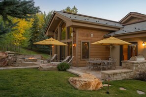 A modern house with a patio area featuring outdoor furniture, a fire pit, and stone accents. - 2 Miles to Downtown Ketchum | Game Room (Sun Valley)