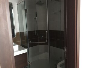 A glass-enclosed shower stall with a white sink and a mirror. - Northern Stella Homestay (Hanoi)
