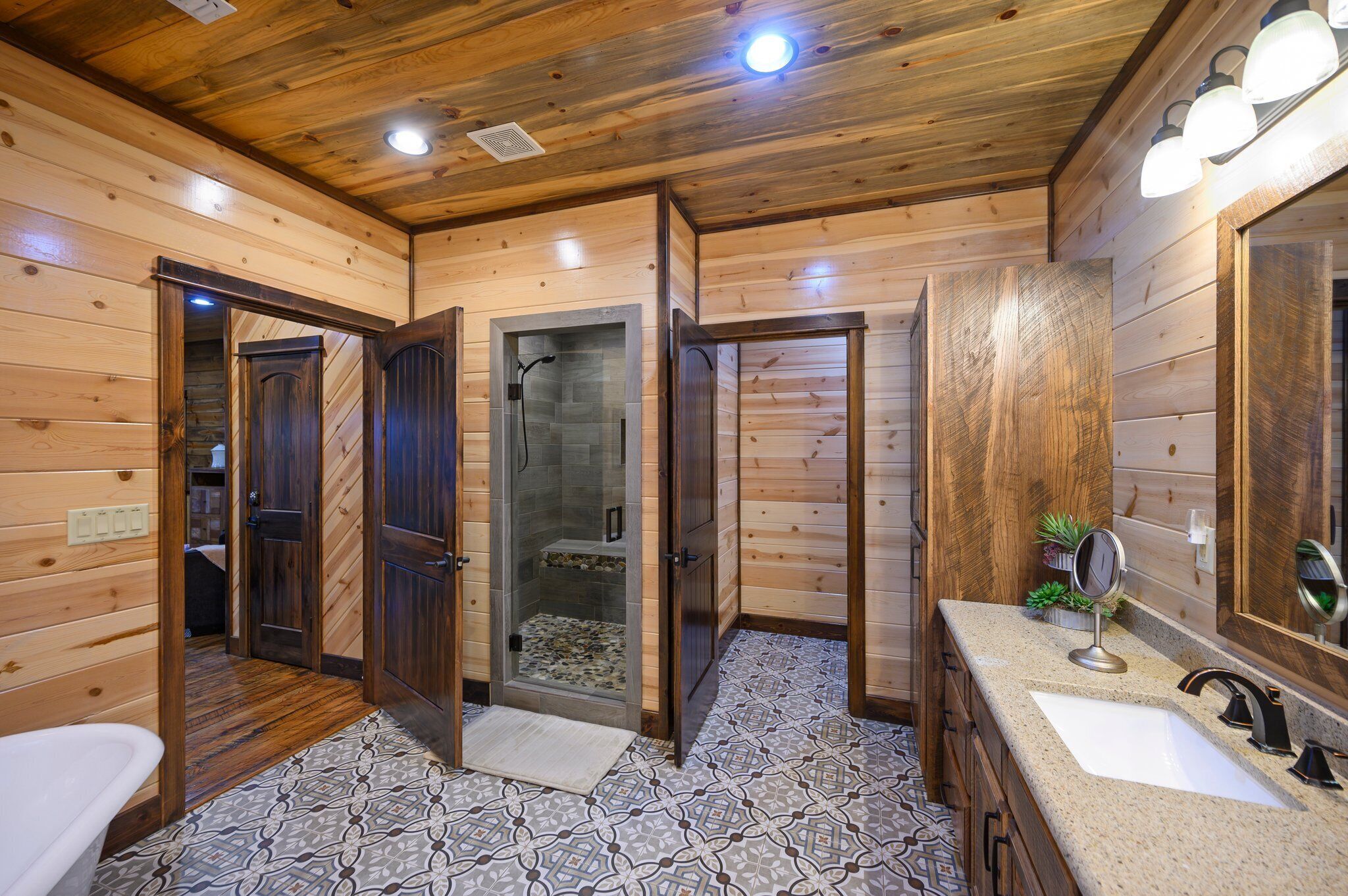 A wooden interior with a shower, two sinks, and a mirror.
