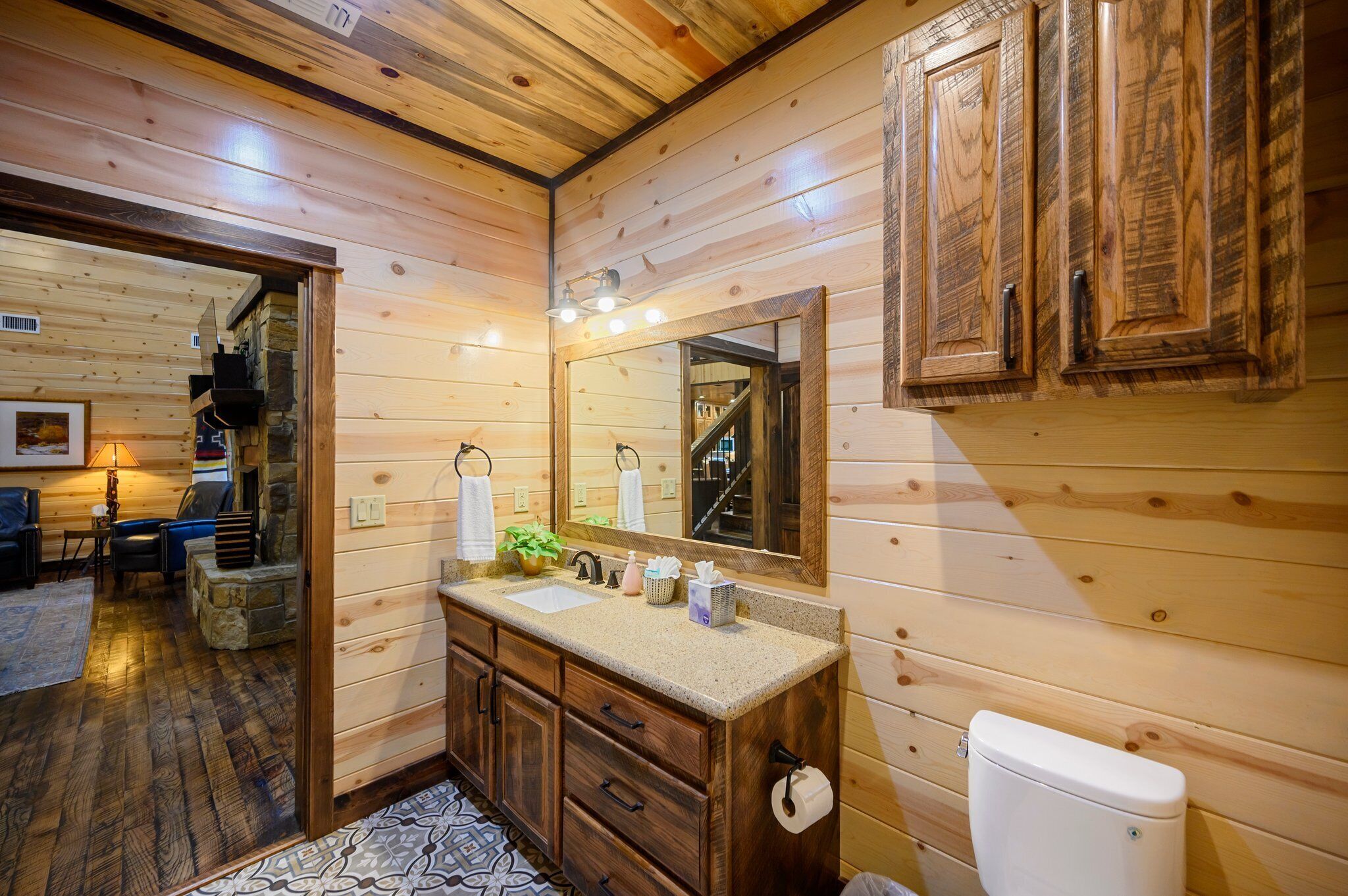 A wooden cabin bathroom with a wooden vanity, sink, and toilet.