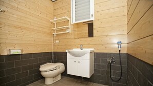 A bathroom with a wooden wall, a white sink, a toilet, and a shower. - Chulu Ecological Farm B&B (Beinan)