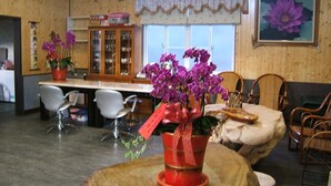 A room with a wooden interior, a dining area with chairs, a table, and a cabinet with glass doors. - Chulu Ecological Farm B&B (Beinan)