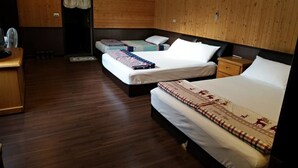 A hotel room with three beds, wooden flooring, and a wooden wall. - Chulu Ecological Farm B&B (Beinan)