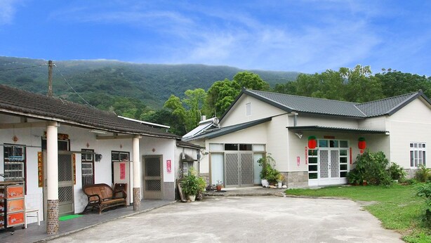 A traditional building with a tiled roof, a covered entrance, and a small porch area with a bench. - Chulu Ecological Farm B&B (Beinan)