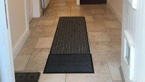 Un pasillo con un tapete negro que conduce a una escalera.