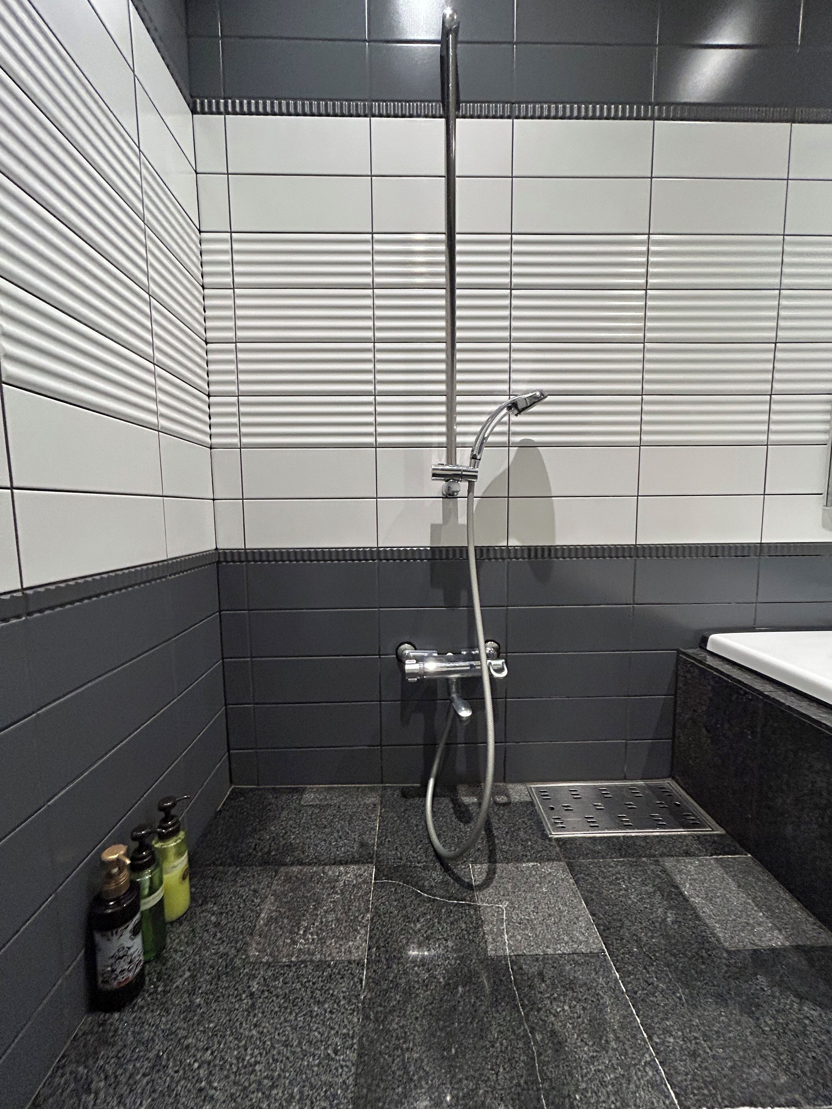 A modern bathroom with a shower, tiled walls, and a sink area.