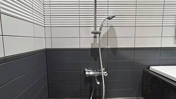 A modern bathroom with a shower, tiled walls, and a sink area.