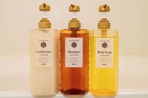 Three bottles of shower products with labels, each with a pump dispenser.