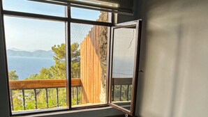 A hot tub with a view of the sea through a large window. - Faralia Hotel (Fethiye)