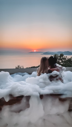 A couple embracing in a hot tub with a sunset view. - Faralia Hotel (Fethiye)