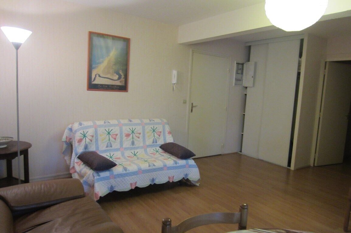 A living room with a sofa, a lamp, and a painting on the wall.