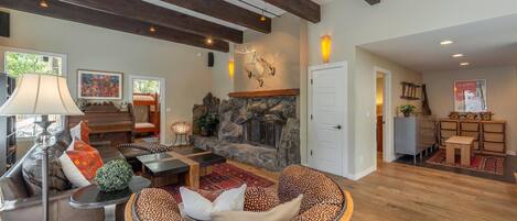 Amplia sala de estar con chimenea, vigas de madera y un espacio de estar acogedor.