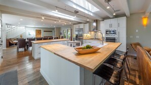 Une cuisine spacieuse dotée d’un grand îlot central, d’appareils électroménagers modernes et d’une lucarne.