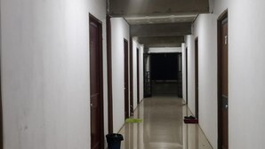 A long, narrow hallway with white walls and doors on both sides. - Mulu Diana Homestay (Mulu)