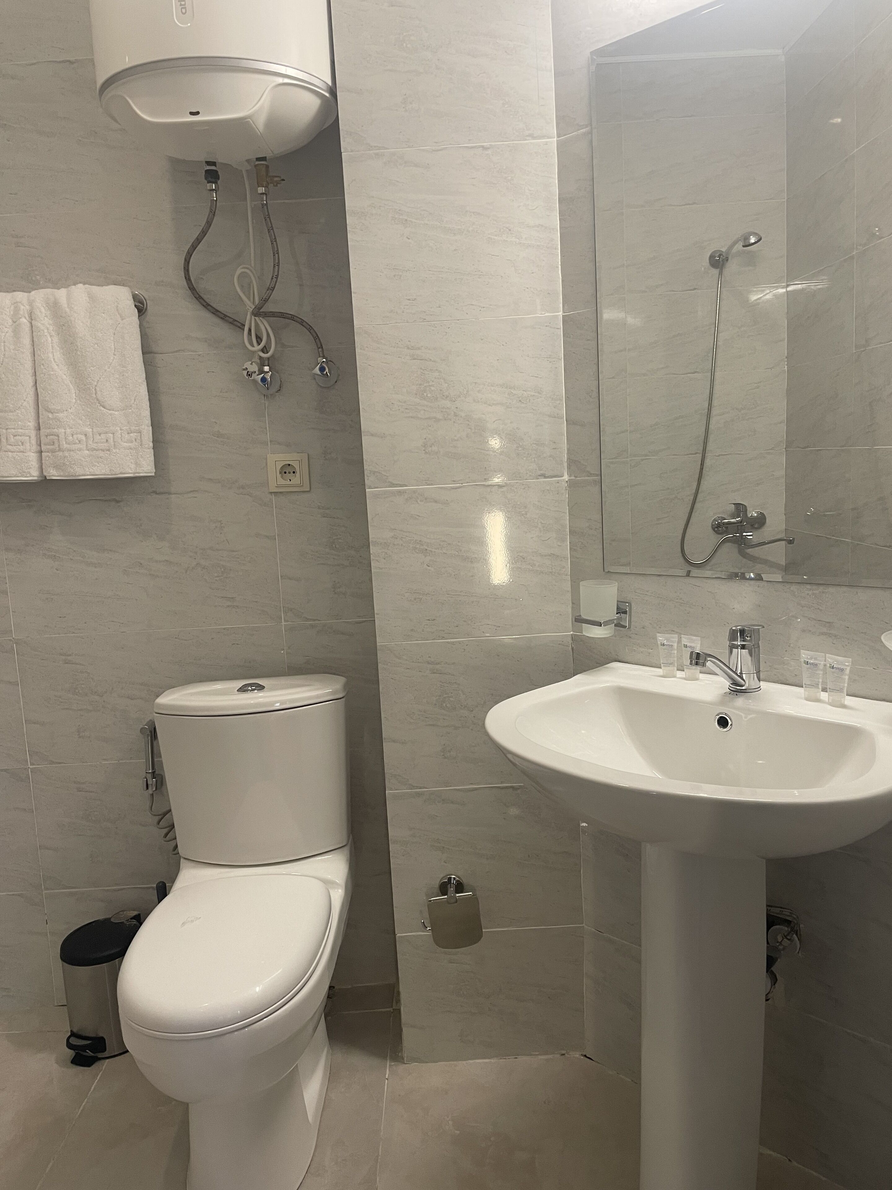 Un baño con inodoro, lavabo y ducha.