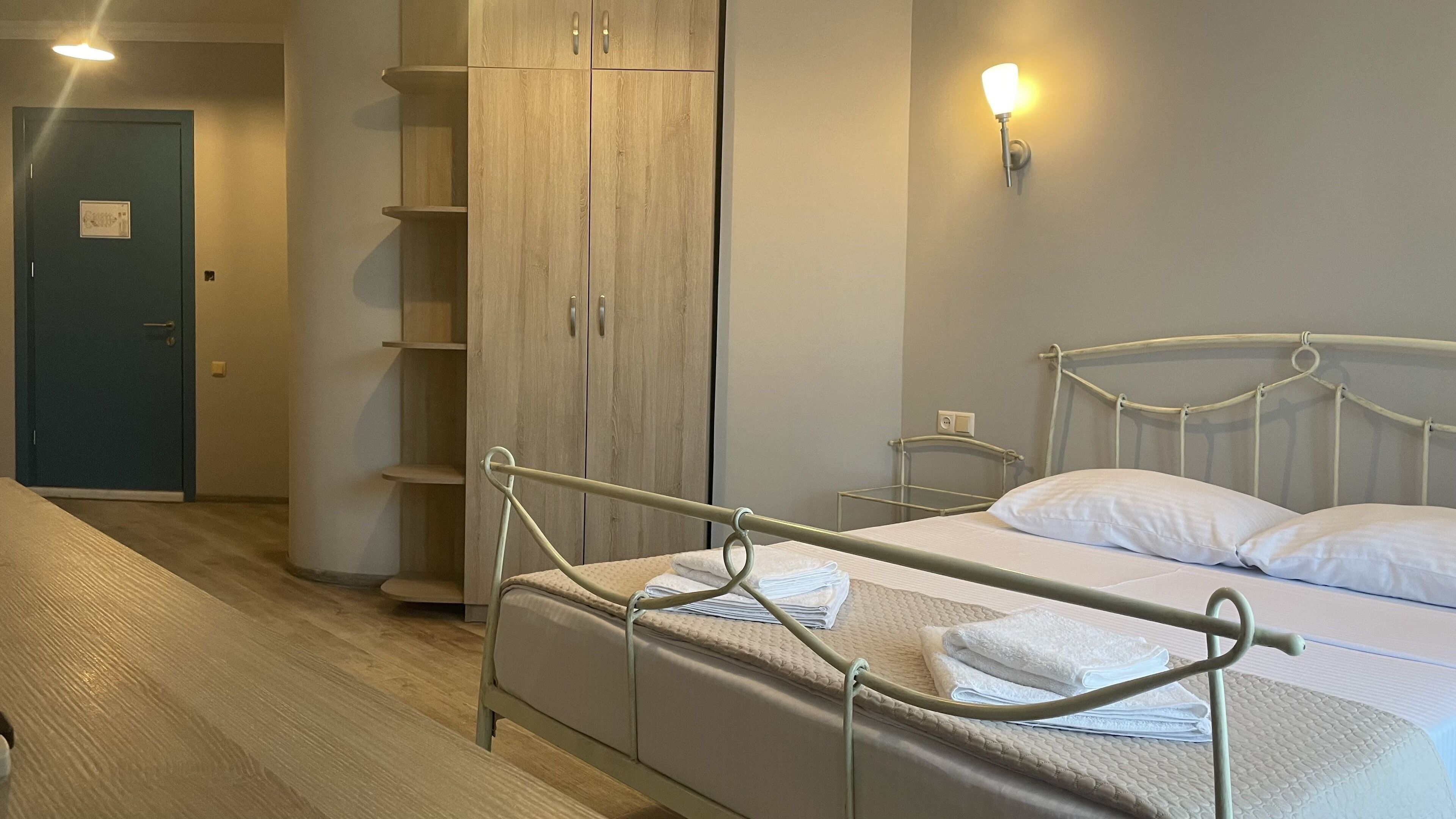Un dormitorio con cama, armario y mesita de noche.